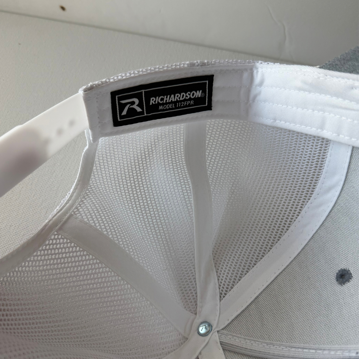 Interior of Veien heather grey and white cap showing white mesh, sweatband, and Richardson 112FPR label.