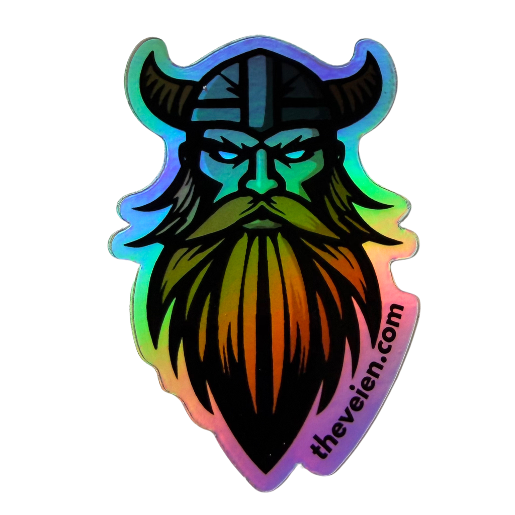 An iridescent holographic sticker featuring a stylized Viking head with a long beard and horned helmet, shown on a plain white background. The sticker has a black base with a rainbow holographic finish and the text 'thevielen.